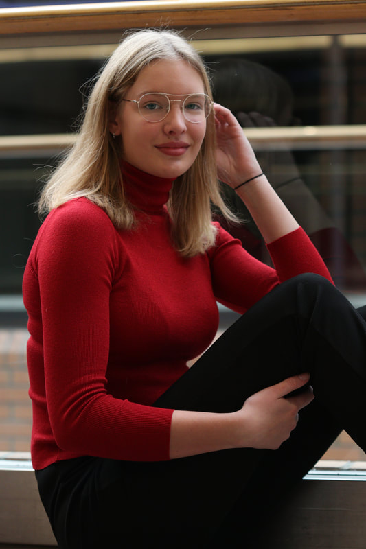 portret zittend meisje met bril rode trui winkelcentrum eindhoven